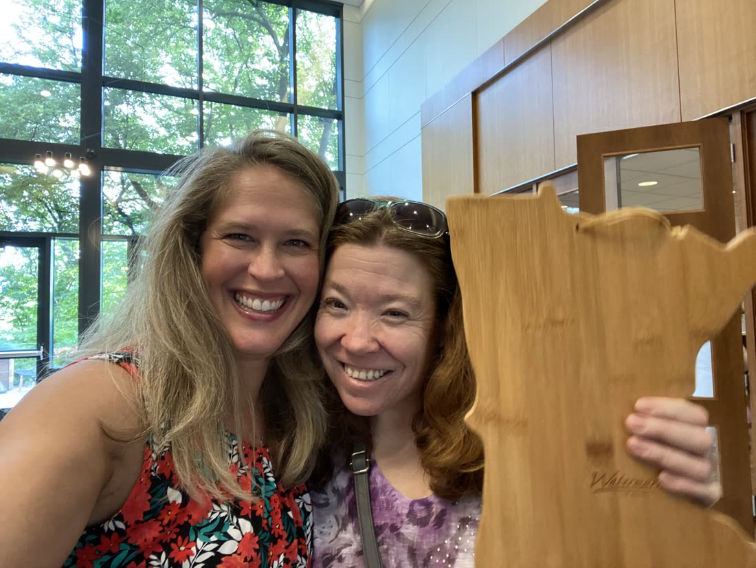 Andrea Scanlon with a client holding a Minnesota-shaped closing gift